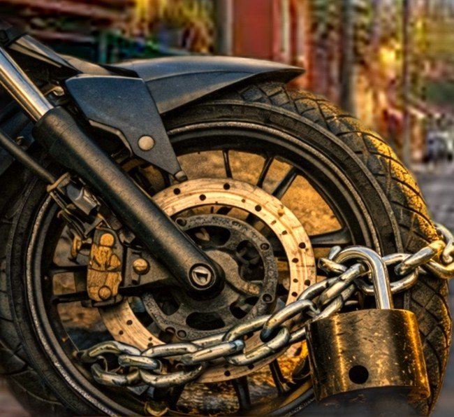 Motocicleta asegurada y protegida con cadena en una calle de Costa Rica
